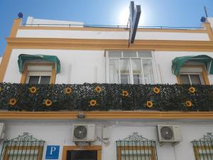 un edificio con un balcón con girasoles. en Hospederia Islasol, en San Fernando
