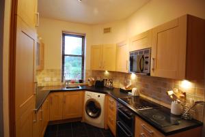 una cocina con lavadora y secadora. en Stornoway Apartment en Stornoway