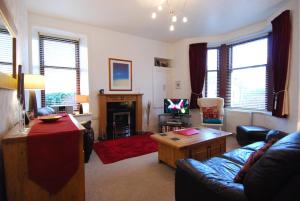 a living room with a couch and a tv at Stornoway Apartment in Stornoway