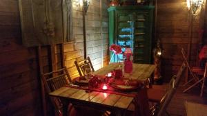einen Holztisch und Stühle mit einer Kerze darauf in der Unterkunft Au Soleil Mongol in Sorède