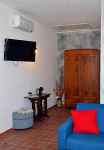 salon z niebieską kanapą i telewizorem w obiekcie Agriturismo La Spiga w mieście Montecatini Val di Cecina