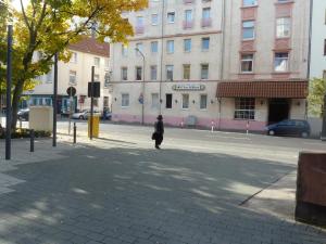 Eine Frau, die vor einem Gebäude die Straße hinuntergeht. in der Unterkunft Relax in Offenbach