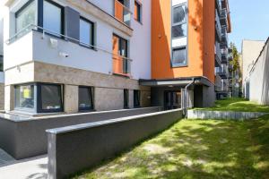 an apartment building with a green lawn in front of it at Good Time Apartments Strzelecka A in Poznań