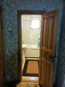 ベルゴロドにあるGuest House on Vologodskiy 5のバスルーム(バスタブ、シンク付)、窓が備わります。