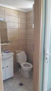 a bathroom with a toilet and a sink at Petani Beachside Accommodation in Vóvikes
