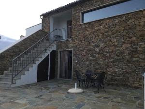 a patio with two chairs and a staircase next to a building at Casas do Bairrinho in Sambade