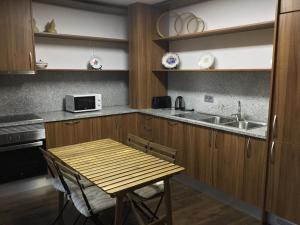 a kitchen with a wooden table and a sink at Casas do Bairrinho in Sambade