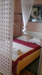 a bedroom with a bed with a canopy at Apartments Mia in Podgora