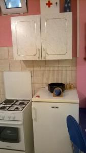 a small kitchen with a stove and white cabinets at Apartments Mia in Podgora