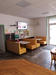 Cercy-la-TourにあるHotel du siecleのテーブル、椅子、テレビが備わる待合室