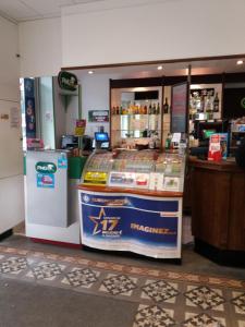 a store with a refrigerator and a counter at Hotel du siecle in Cercy-la-Tour