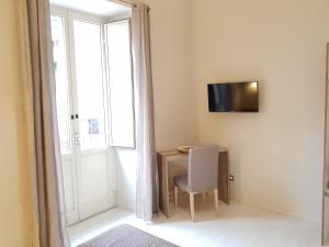 ナポリにあるRelais Borbonicoのテーブルと椅子、窓が備わる客室です。