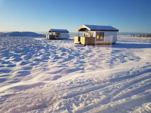two houses on the beach in the snow at Hekla Cabin 2 Volcano and Glacier View in Hella