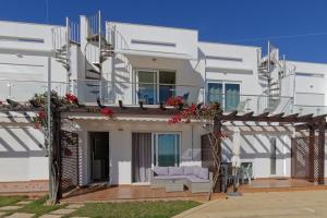 une maison blanche avec 2 chaises sur une terrasse dans l'établissement Oasis Praia Carvoeiro Bay, à Carvoeiro
