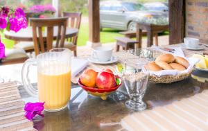 una mesa con un bol de fruta y un vaso de zumo de naranja en San Mateo Hotel Campestre, en Nobsa
