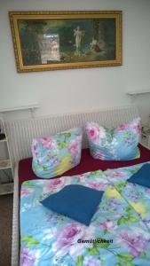 2 Betten mit Kissen und ein Bild an der Wand in der Unterkunft Ferienwohnungen im Fachwerkhaus in Quedlinburg