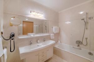 a bathroom with a sink and a tub and a mirror at Appartment Maria in Schenna +70 photos