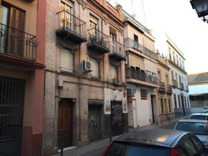 um edifício com carros estacionados ao lado de uma rua em Casas de Sevilla - Estudio Peral 55 em Sevilha