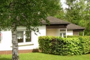 una casa blanca con un árbol en el patio en Ferienpark Wehrda GmbH en Wehrda