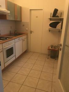 eine Küche mit Tür und Fliesenboden in der Unterkunft Ferienwohnung "Am Rothaarsteig" in Winterberg