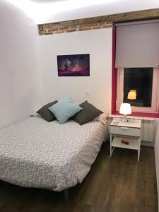 - une chambre avec un lit, un bureau et une fenêtre dans l'établissement AIRVA: Apartamento Duque de la Victoria, à Valladolid