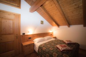 una camera da letto con un letto e un soffitto in legno di Casa Le Rondini a Valdisotto Altre 74 foto