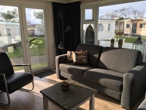 a living room with a couch and a chair at Chalet Zeester J38 Ameland in Buren