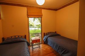 two beds in a room with a window at Cabañas Nogalia in San Alfonso