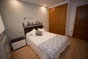 - une chambre avec un lit blanc et une porte en bois dans l'établissement Almudena, à Teruel