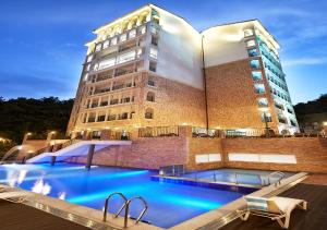 un bâtiment avec une piscine en face d'un bâtiment dans l'établissement Hotel Thesoom Forest, à Yongin