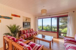 a living room with couches and a large window at Cabañas Cantomar in Pichilemu