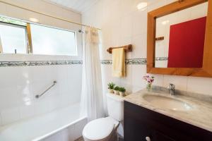 a bathroom with a toilet and a sink and a mirror at Cabañas Cantomar in Pichilemu +18 photos