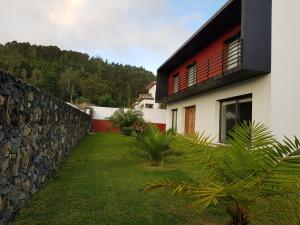 una casa con una pared de piedra junto a un patio en Deluxe Home Praia do Populo, en Cabouco