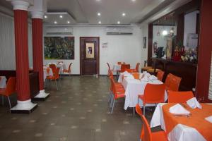 un comedor con mesas, sillas y columnas rojas en Gran Hotel Marien en Sabaneta