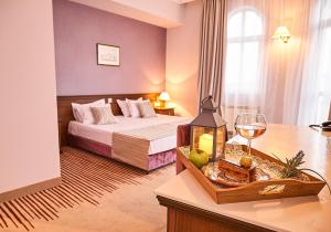 a hotel room with a bed and a glass of wine at Hotel Lion Sofia in Sofia