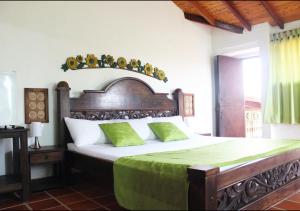 1 dormitorio con 1 cama grande y cabecero de madera en Hotel Cristo Rey Campestre, en Los Santos