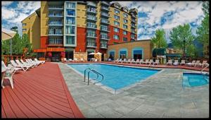 a large hotel with a swimming pool in front of a building at Powder's Edge by LaTour Hotels and Resorts in Whistler