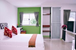 Golden On-nut في بانكوك: غرفة نوم بسرير ابيض وجدار اخضر