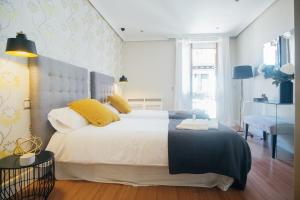 A bed or beds in a room at Heima Puerta del Sol - Plaza Santa Ana