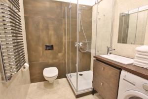 a bathroom with a shower and a toilet and a sink at Apartamenty Stary Rynek Bydgoszcz in Bydgoszcz +18 photos