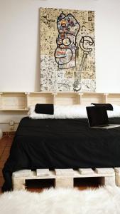ナポリにあるArt house in the artist workspace in the centerのベッドルーム1室(ベッド2台付)が備わります。壁には絵画が飾られています。