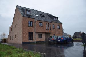 a brick building with a car parked in front of it at Hotel Apartments Belgium 3 - HAB 3 in Geel