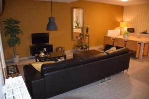 a living room with a black couch and a table at Hotel Apartments Belgium 3 - HAB 3 in Geel