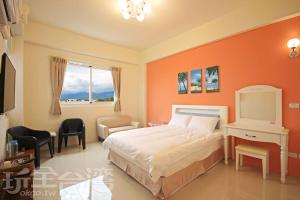 ein Schlafzimmer mit einem Bett mit einer orangefarbenen Wand in der Unterkunft Hai Bed and Breakfasts in Taitung