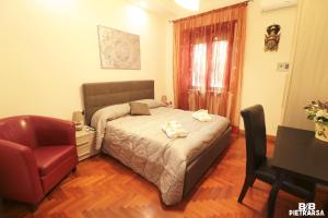 1 dormitorio con cama, silla y escritorio en B&B Pietrarsa, en Portici