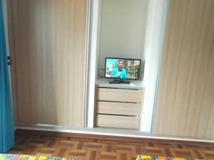 uma televisão sentada numa bancada numa sala em Residência Disaflor em Maceió