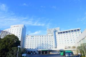 a large white building with a parking lot in front of it at Narita Tobu Hotel Airport in Narita