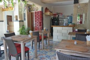 a restaurant with wooden tables and chairs and a kitchen at Duyung Homestay in Sanur