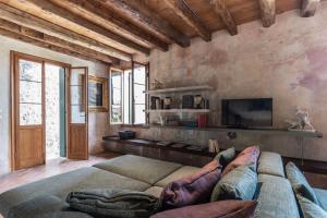 uma sala de estar com um sofá e uma televisão em La Canonica em Asolo