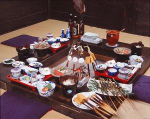 una mesa con muchos platos de comida. en Motoyu Arimaya, en Aizuwakamatsu